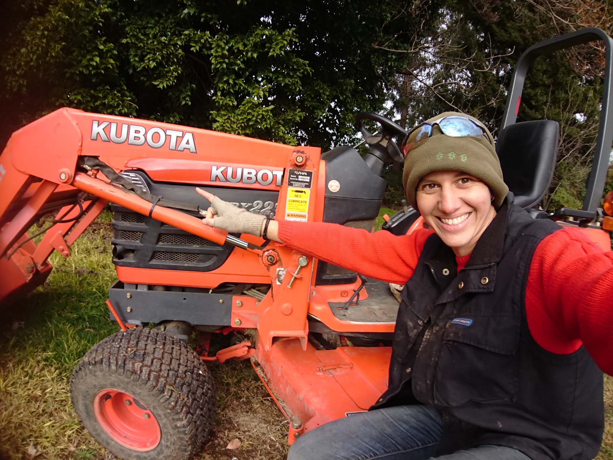 Gamila in front of a Kubota tractor